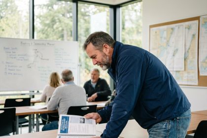Homme d'âge moyen étudie un manuel de navigation dans une classe